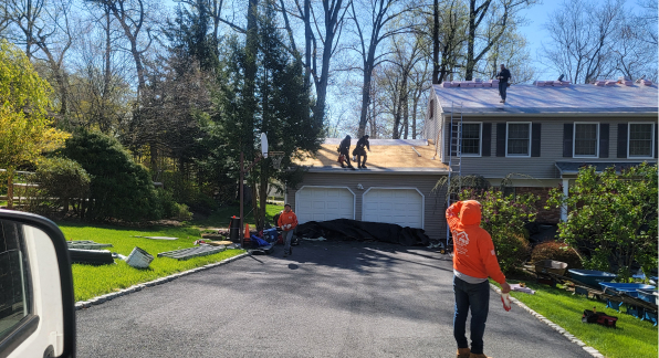 Roofing team replacing the roof of a suburban home.